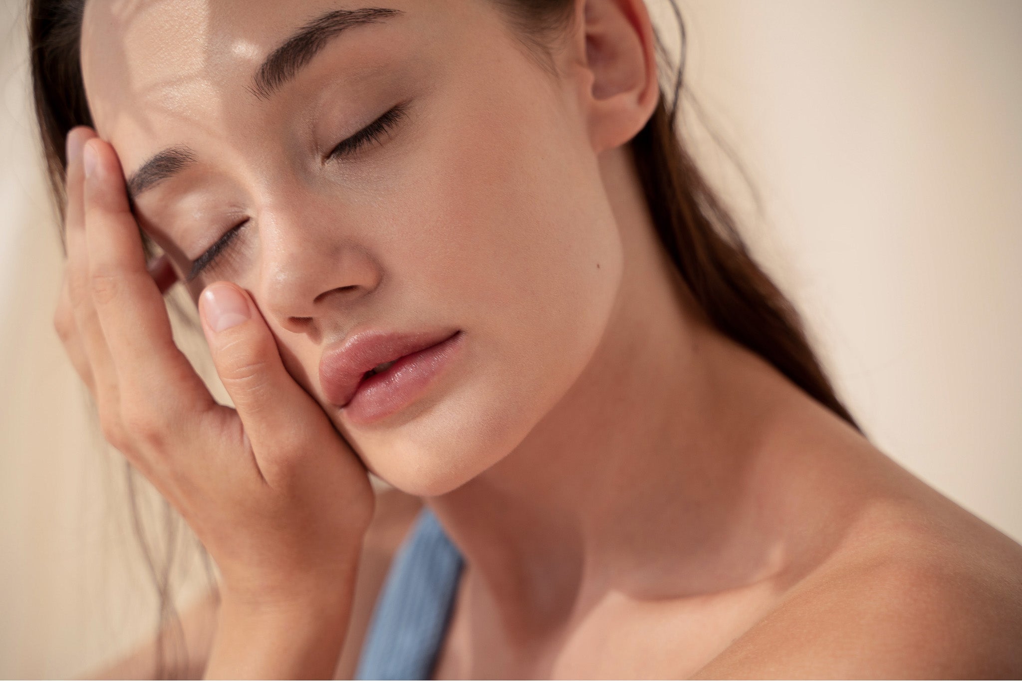 Pelle idratata e rigenerata di una ragazza che si tocca il viso dopo la skincare serale